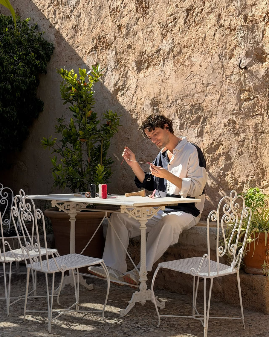 Adrián Salvador bei der Lederarbeit am Tisch im Innenhof